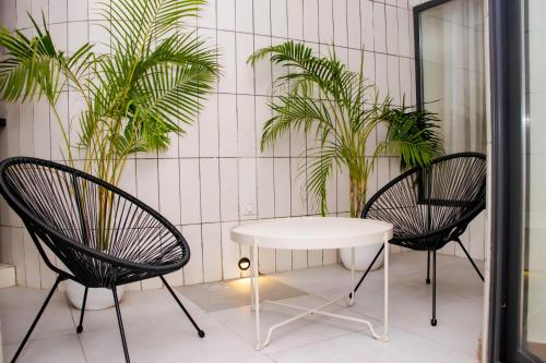 two chairs and a table in a room with plants at Seasons Appart in Cotonou