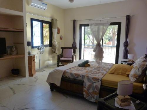 a bedroom with a large bed and a window at villa arborée ngaparou in Ngaparou