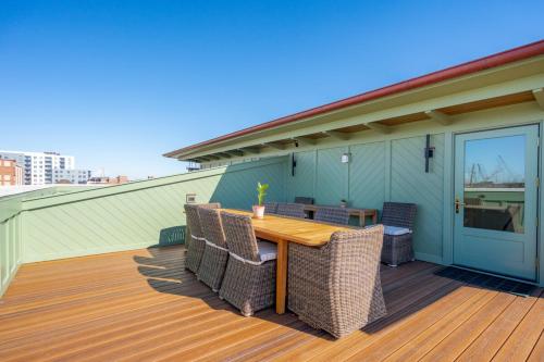 a wooden table and chairs on a deck at The Chateau - By Charleston Vacays in Charleston