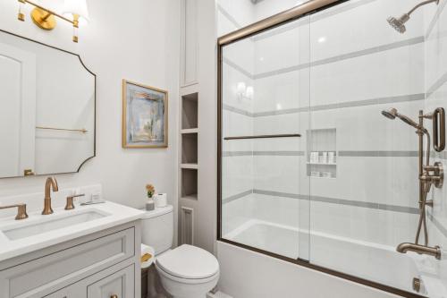 a bathroom with a shower and a toilet and a sink at The Chateau - By Charleston Vacays in Charleston
