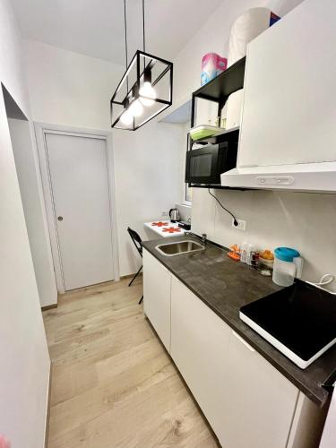 a kitchen with white cabinets and a black counter top at Pamphili Home - Un angolo di pace vicino Trastevere in Rome