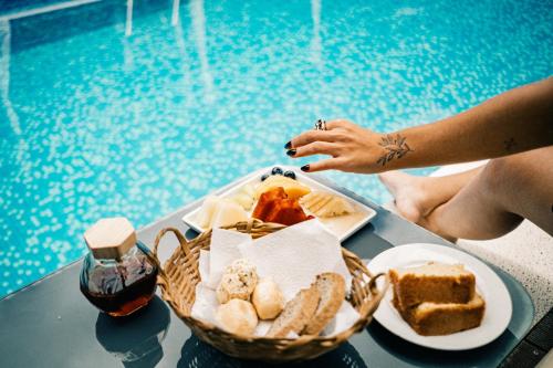 a tray of food on a table next to a pool at Hiu Hotel in Juquei