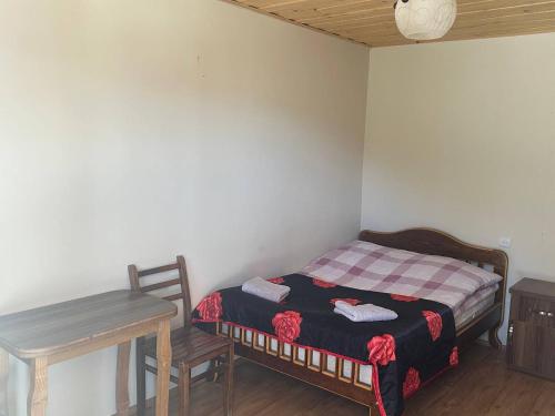 a small bedroom with a bed and a table at Mountain house in Ushguli