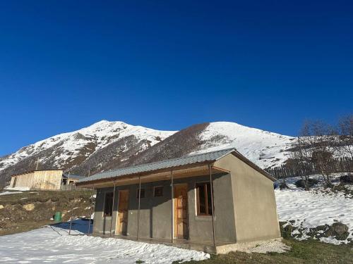 a small house in front of a snow covered mountain at Mountain house in Ushguli