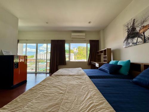 a bedroom with two beds and a large window at Ananas Central Phuket Hostel in Ban Ket Ho