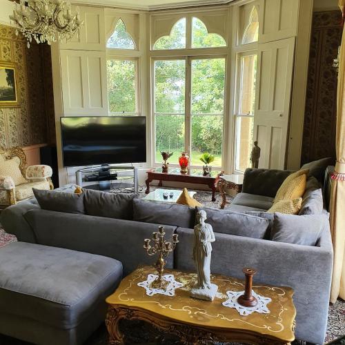 a living room with a couch and a tv at Country Manor House in Higham