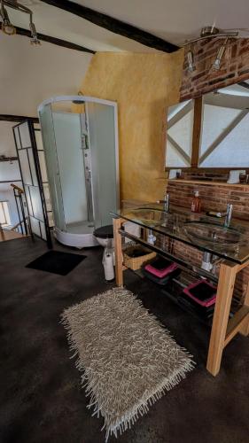 Cette chambre comprend une table en verre et un tapis. dans l'établissement Le Val du Roy, à Joinville
