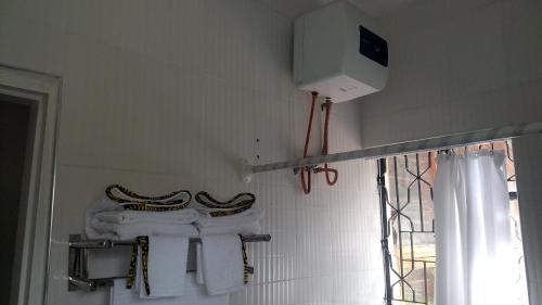 a bathroom with white towels on a rack and a window at Eden Hill Villas - Njiro, Arusha in Nkunjila