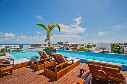 a deck with chairs and a swimming pool at Maravilloso Pent House en 5th Avenida nuevo en plataforma in Playa del Carmen