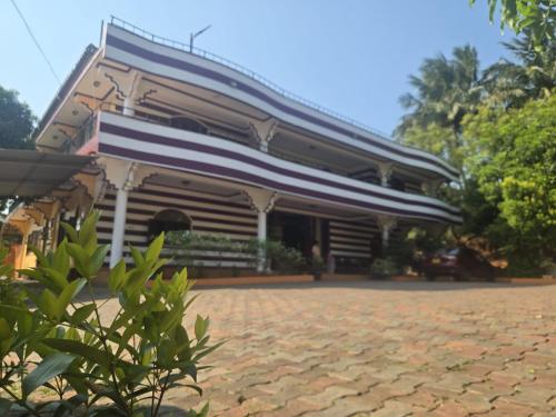 a building with a roof on top of a driveway at Motel Apple Five in Trincomalee
