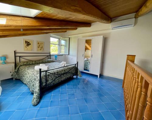 una camera con un letto su un pavimento piastrellato blu di Casale Dionisia, Santa Maria di Castellabate, Appartamento Iris a Castellabate