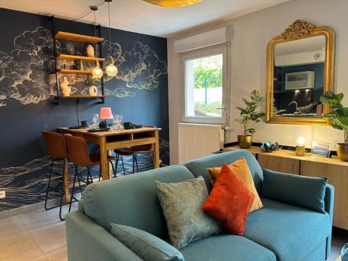 un salon avec un canapé bleu et une table dans l'établissement Retro-chic elegance with terrace near tramway, à Saint-Priest