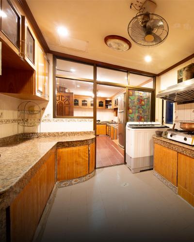 a large kitchen with wooden cabinets and a large window at Bigg Villa at Walking Street in Pattaya South