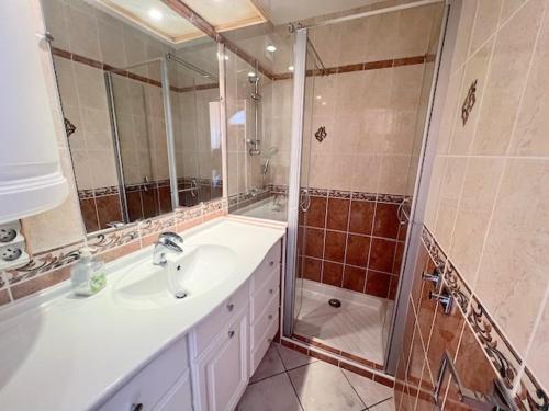 une salle de bain avec un lavabo et une douche dans l'établissement Studio 4, Héliopolis D au village naturiste, au Cap d'Agde
