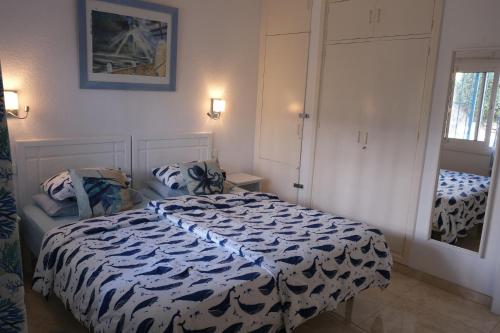 a bedroom with a bed with a black and white comforter at ELENA flat A little paradise right on the BEACH in Sitio de Calahonda