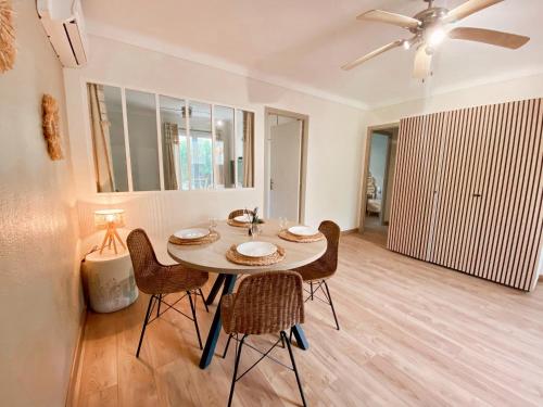 - une table à manger avec des chaises et un ventilateur de plafond dans l'établissement Maison 2 chambres à la plage avec jardin, à Canet
