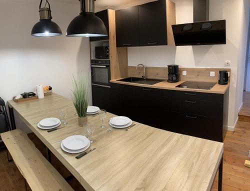 - une cuisine avec une table en bois avec des assiettes et des verres dans l'établissement Maison de vacances insolite - 1-6 pers à Guérande, à Guérande