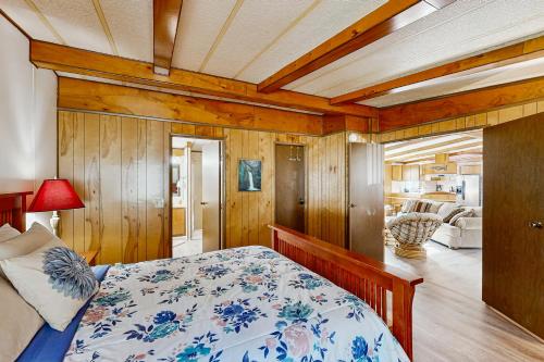 a bedroom with a bed and a living room at Redwood Coast River House in Smith River