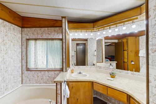 a bathroom with a tub and a sink and a bath tub at Redwood Coast River House in Smith River