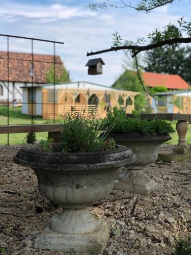 two stone planters with plants in front of a building at Edenski vrt in Ivančna Gorica