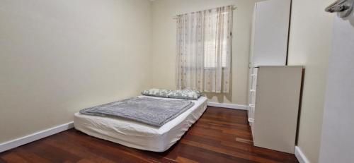 a white room with a bed and a refrigerator at Budget Friendly Couple Room Esperance in Esperance