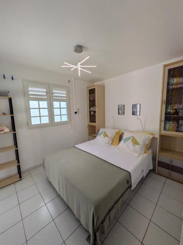 a bedroom with a large bed and a ceiling fan at Oxygène, Havre de paix in Les Anses-dʼArlets