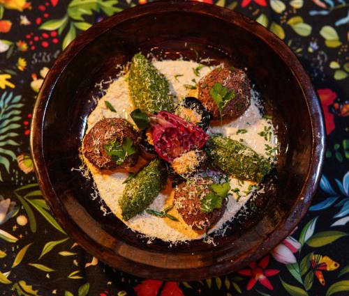 a bowl of food with meat and broccoli on a table at Hotel Roshe Gudauri in Gudauri