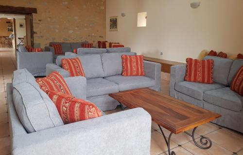 un salon avec des canapés et une table basse dans l'établissement Gite - Le Domaine des Hallais, à Saint-Pierre-sur-Erve