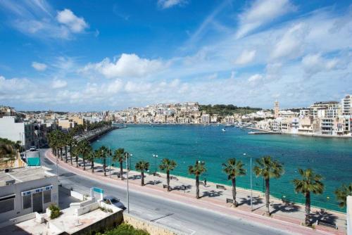 a view of a beach with palm trees and buildings at Sea View 2 Bed Apartment close to beach Hpi6768 in Il-Maħsel