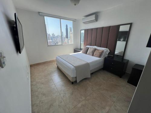 a bedroom with a bed and a large window at Acogedor apartamento en El Cangrejo in Panama City