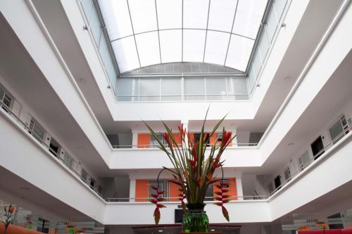 een vaas met bloemen in een kamer met een plafond bij Hotel Ferias Park in Bogota