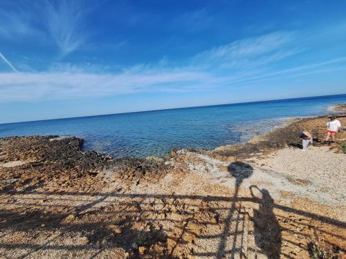 two people standing on a beach near the water at Big house in center of protaras, near beach in Protaras
