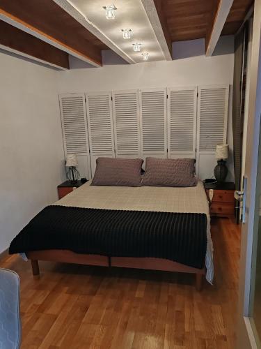 - une chambre avec un grand lit et du parquet dans l'établissement Appartement T2 sur cour nantaise, à Rezé