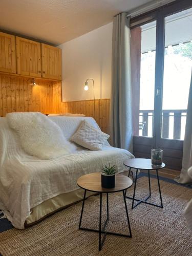- une chambre avec un grand lit et 2 tables dans l'établissement Riviera Lodge, à Allos
