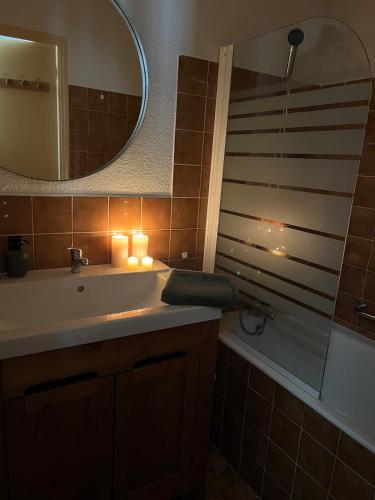 une salle de bain avec un lavabo, un miroir et une baignoire dans l'établissement Riviera Lodge, à Allos