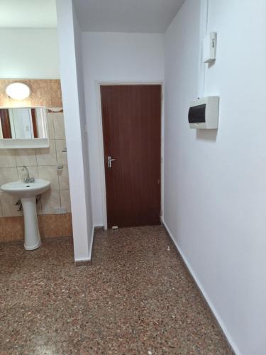 a bathroom with a toilet and a sink and a door at Big house in center of protaras, near beach in Protaras