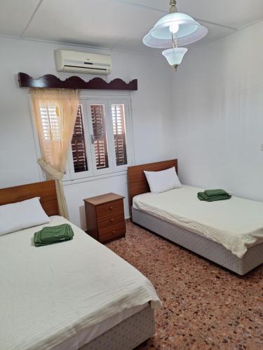 a bedroom with two beds and a chandelier at Big house in center of protaras, near beach in Protaras