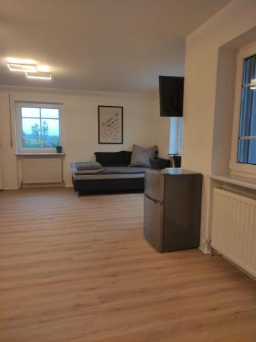 a living room with a couch and a television at Sonniges und modernes Apartment Casa Nobi in Gebenbach