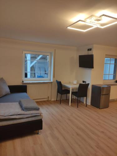 a bedroom with a bed and a table and chairs at Sonniges und modernes Apartment Casa Nobi in Gebenbach