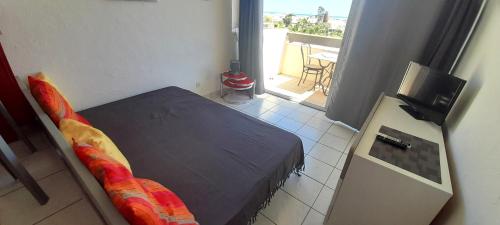 Cette petite chambre comprend un lit et une télévision. dans l'établissement Studio 729, Port Nature 7 au village naturiste, au Cap d'Agde