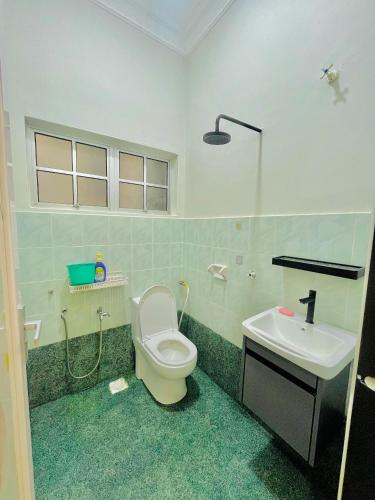 ein Badezimmer mit Toilette und Waschbecken in der Unterkunft Homestay Deedora 87 in Seri Manjung