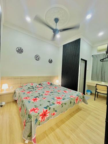 ein Schlafzimmer mit einem Bett mit geblümter Tagesdecke in der Unterkunft Homestay Deedora 87 in Seri Manjung