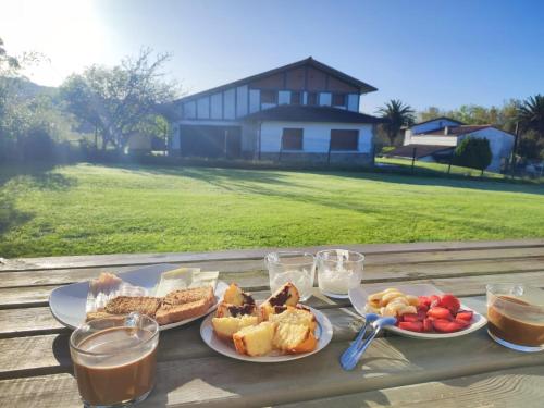 a table with plates of food and glasses of milk at Urrumendi in Mungia