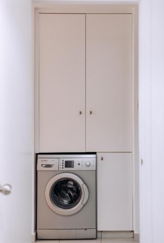 a washing machine in a room with white cabinets at Stunning Sea & Sky View- 3BR, Pool ,Amazing Balcony in Trimitusa