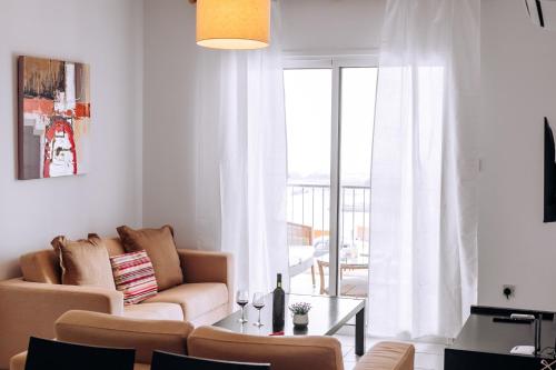 a living room with a couch and a large window at Stunning Sea & Sky View- 3BR, Pool ,Amazing Balcony in Trimitusa