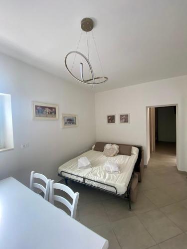 a bedroom with a bed and a table and a chandelier at Maison Federica in Colà di Lazise