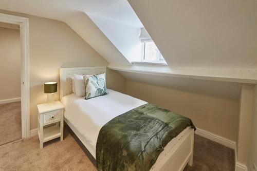 a bedroom with a white bed in a attic at Painters Modern Apartment Central Location in Scarborough