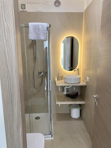 a bathroom with a shower and a sink and a mirror at Maison Federica in Colà di Lazise