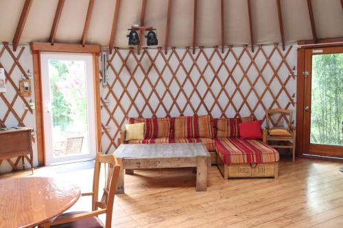 - une chambre avec un canapé et une table dans une yourte dans l'établissement Les Yourtes du Perche, à Coulonges-sur-Sarthe