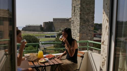 two women sitting at a table eating food on a balcony at Nonna Rina b&b in Savona